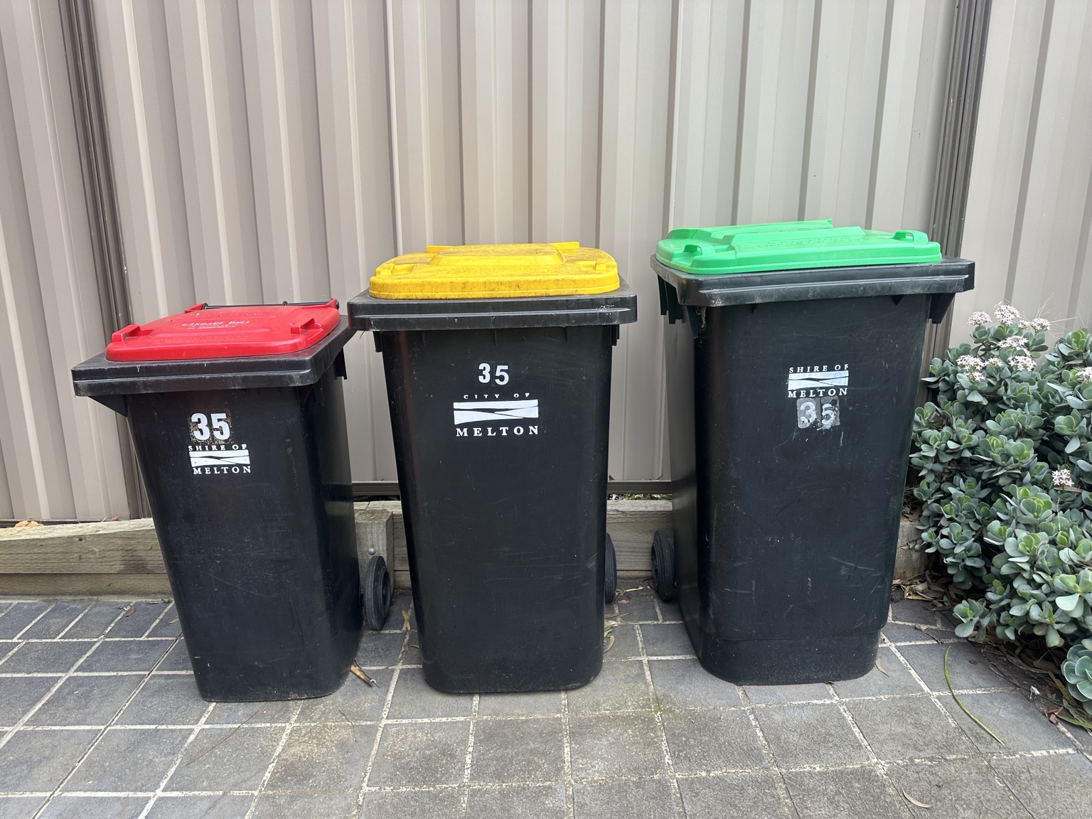 Three clean Melton general waste, recycling, and green waste bins